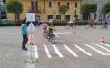 Due ciclisti danno la precedenza a un pedone che attraversa sulle strisce pedonali